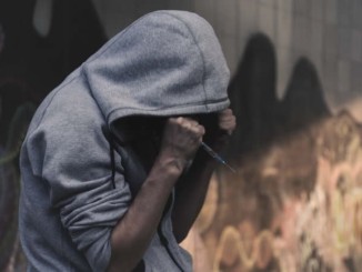 Drug addict holding syringe