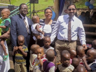 Santosh Gumte, left, the Kansai Plascon Uganda Managing Director, with staff members of Sanyu Babies Home at the handover of proceeds from sales of Plascon's anti-mosquito paint