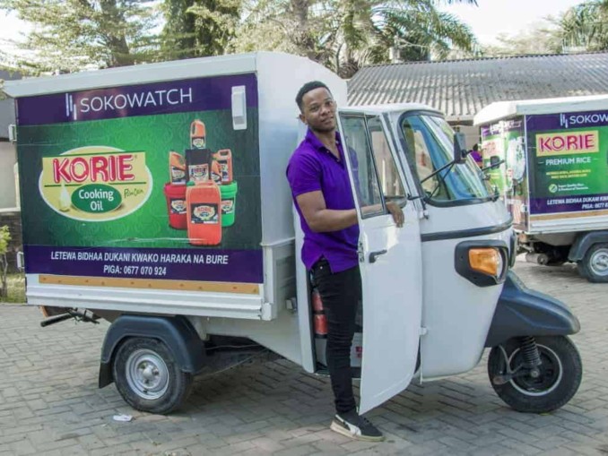 A driver standing next to his tuk-tuk